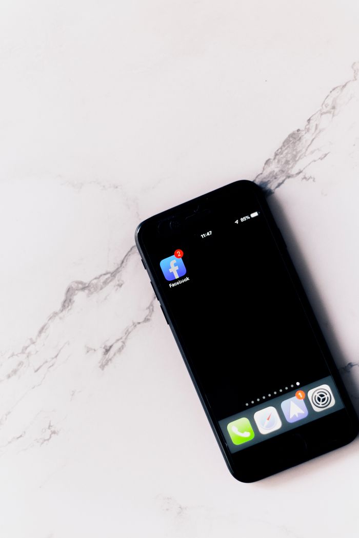 Close-up of a smartphone with Facebook app notification on a marble surface.